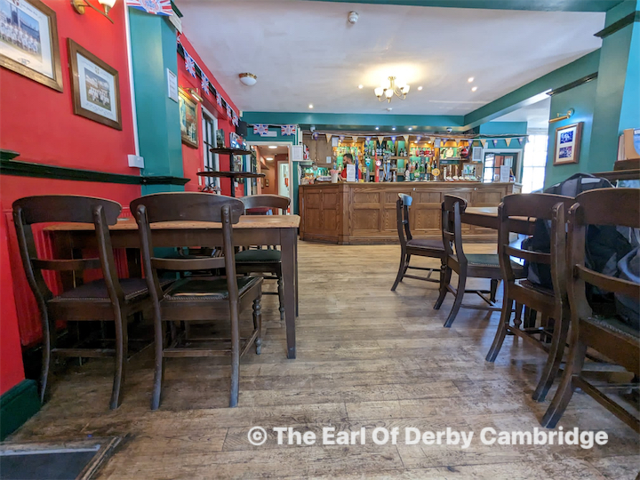 DJ facing a crowd at his deck. Photo with a purple hue