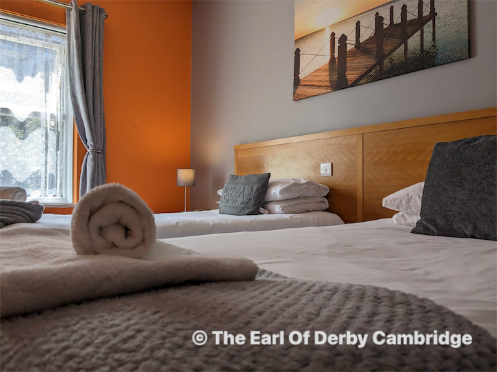 DJ facing a crowd at his deck. Photo with a purple hue